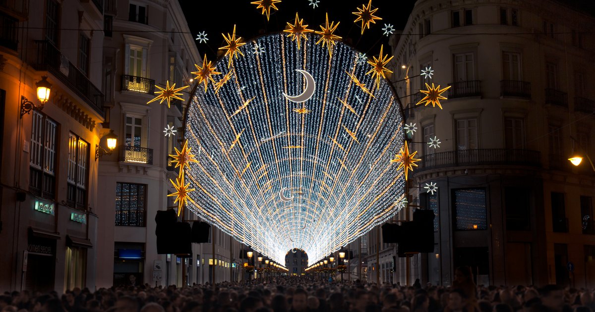 Christmas lights illuminating a street in Malaga at night