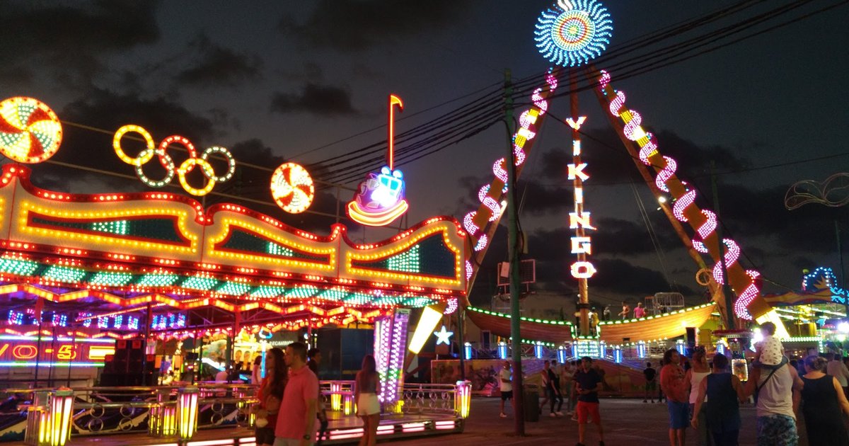 The Feria de Malaga lit up at night with crowds and decorations